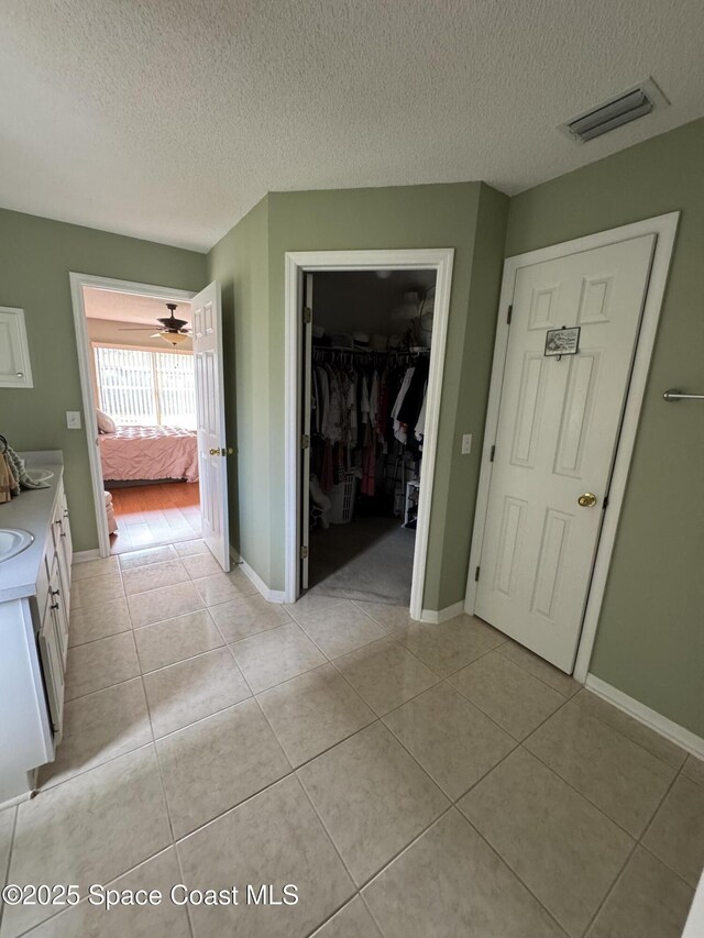 157 Lehigh Ave SE, Palm Bay, FL 32909 - hall featuring a textured ceiling, light tile patterned flooring, and baseboards