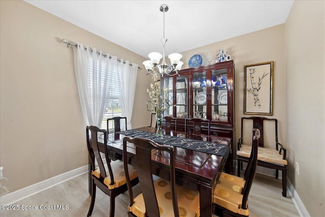 1478 Gray St SE, Palm Bay, FL 32909 - dining area with a chandelier, baseboards, and light wood-style flooring