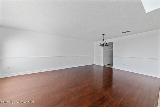 1500 La Maderia Dr SW, Palm Bay, FL 32908 - unfurnished room with a chandelier, dark wood-style floors, a textured ceiling, and baseboards