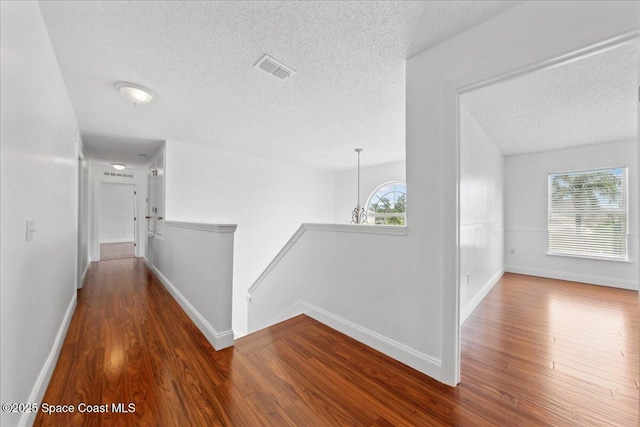 1500 La Maderia Dr SW, Palm Bay, FL 32908 - corridor with a textured ceiling, wood finished floors, plenty of natural light, and baseboards