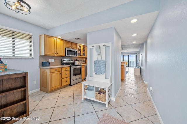 3901 Dixie Hwy NE Unit 301, Palm Bay, FL 32905 - kitchen with stainless steel appliances, light countertops, light tile patterned flooring, baseboards, and recessed lighting