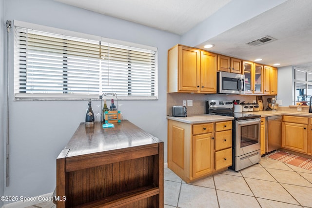 3901 Dixie Hwy NE Unit 301, Palm Bay, FL 32905 - kitchen featuring appliances with stainless steel finishes, healthy amount of natural light, light countertops, glass insert cabinets, and recessed lighting