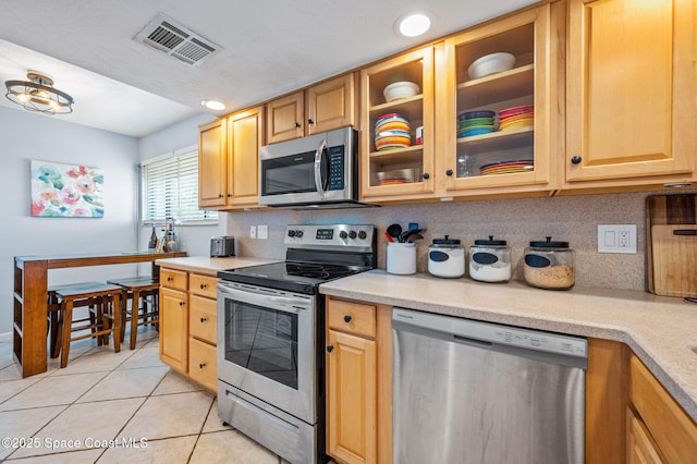 3901 Dixie Hwy NE Unit 301, Palm Bay, FL 32905 - kitchen with stainless steel appliances, light tile patterned floors, light countertops, and tasteful backsplash