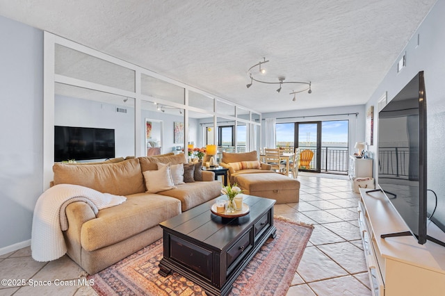 3901 Dixie Hwy NE Unit 301, Palm Bay, FL 32905 - living room with light tile patterned floors, baseboards, a textured ceiling, and track lighting
