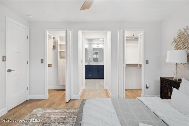 629 Verbenia Dr, Satellite Beach, FL 32937 - bedroom featuring a spacious closet, a closet, light wood-type flooring, and ensuite bathroom