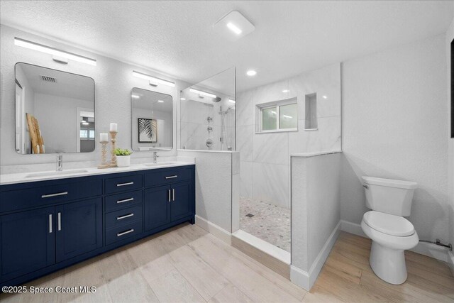 629 Verbenia Dr, Satellite Beach, FL 32937 - bathroom with double vanity, wood finished floors, toilet, walk in shower, and recessed lighting