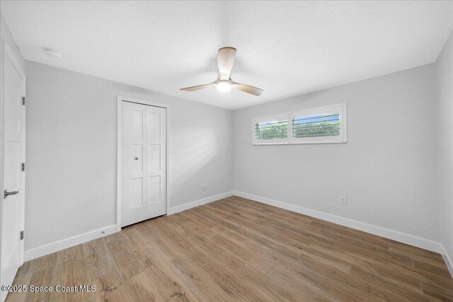629 Verbenia Dr, Satellite Beach, FL 32937 - unfurnished bedroom with light wood-style flooring, a closet, baseboards, and a ceiling fan