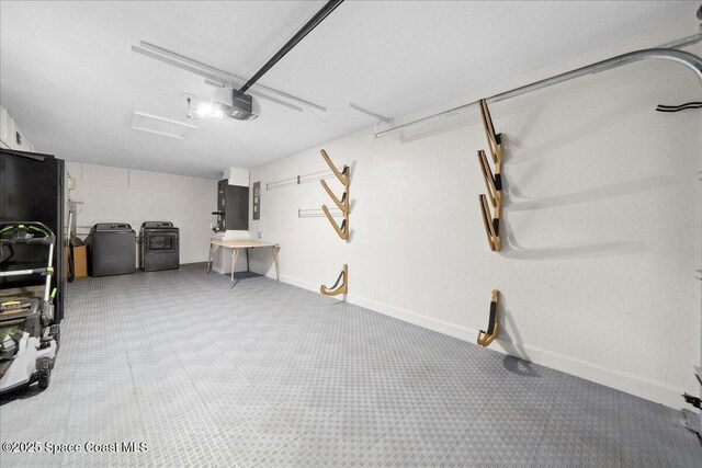 629 Verbenia Dr, Satellite Beach, FL 32937 - garage featuring washing machine and clothes dryer, a garage door opener, baseboards, and electric panel