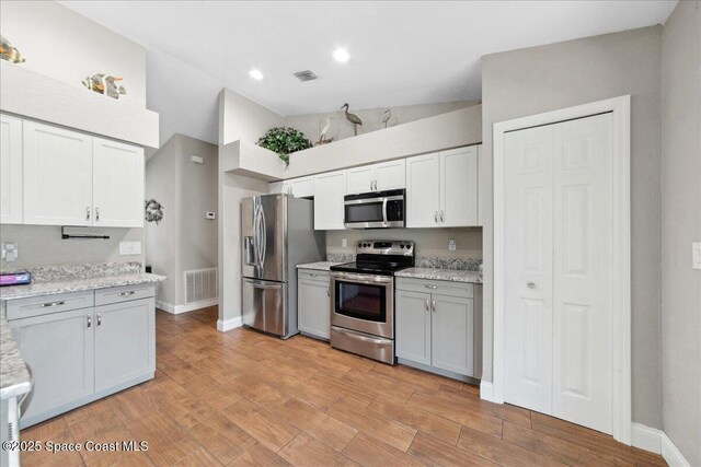 1911 Crane Creek Blvd, Melbourne, FL 32940 - kitchen with appliances with stainless steel finishes, baseboards, white cabinetry, light wood finished floors, and recessed lighting