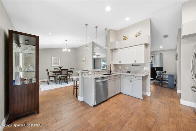 1911 Crane Creek Blvd, Melbourne, FL 32940 - kitchen with stainless steel dishwasher, a sink, a peninsula, white cabinets, and light wood-style flooring