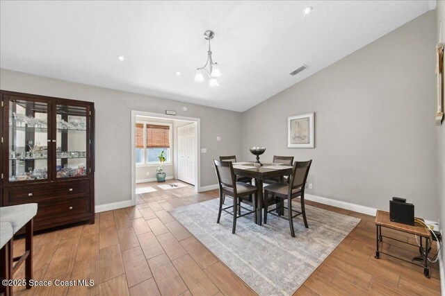 1911 Crane Creek Blvd, Melbourne, FL 32940 - dining area featuring vaulted ceiling, wood finished floors, and baseboards