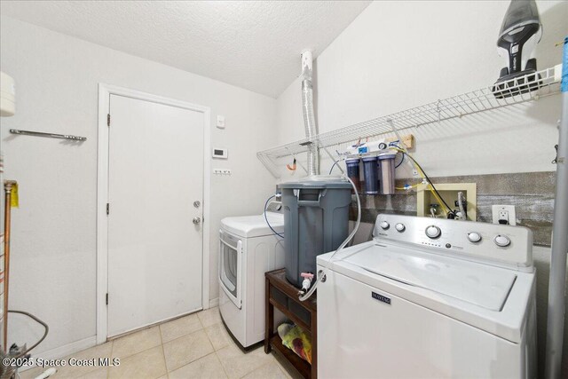 1911 Crane Creek Blvd, Melbourne, FL 32940 - washroom with independent washer and dryer, light tile patterned floors, a textured ceiling, and baseboards