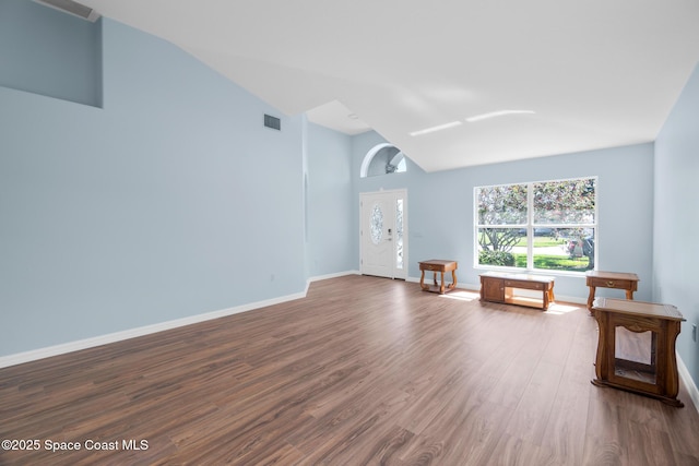 1685 Timacuan Dr, Melbourne, FL 32940 - unfurnished living room with lofted ceiling, dark wood-type flooring, and baseboards