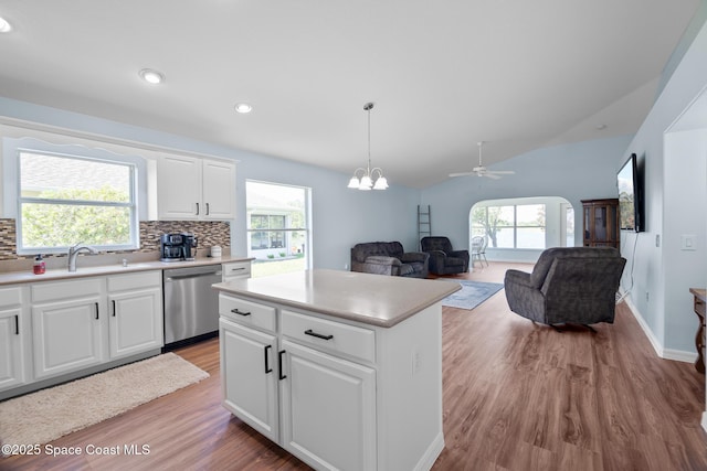 1685 Timacuan Dr, Melbourne, FL 32940 - kitchen with dishwasher, a sink, light wood finished floors, backsplash, and plenty of natural light