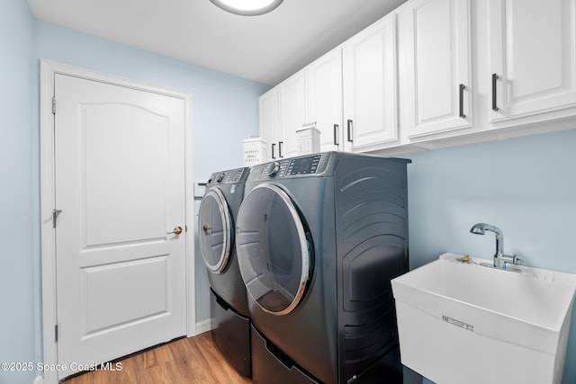 1685 Timacuan Dr, Melbourne, FL 32940 - laundry room featuring cabinet space, separate washer and dryer, and light wood-style flooring