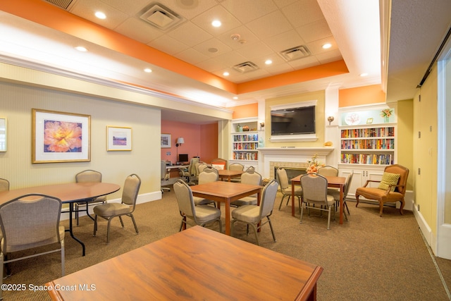 1685 Timacuan Dr, Melbourne, FL 32940 - carpeted dining space featuring a raised ceiling, baseboards, a fireplace, built in shelves, and recessed lighting