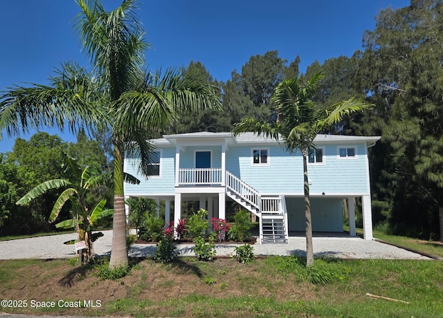 9470 Hibiscus Ave, Sebastian, FL 32976 - view of front facade with a carport, stairway, dirt driveway, and a porch