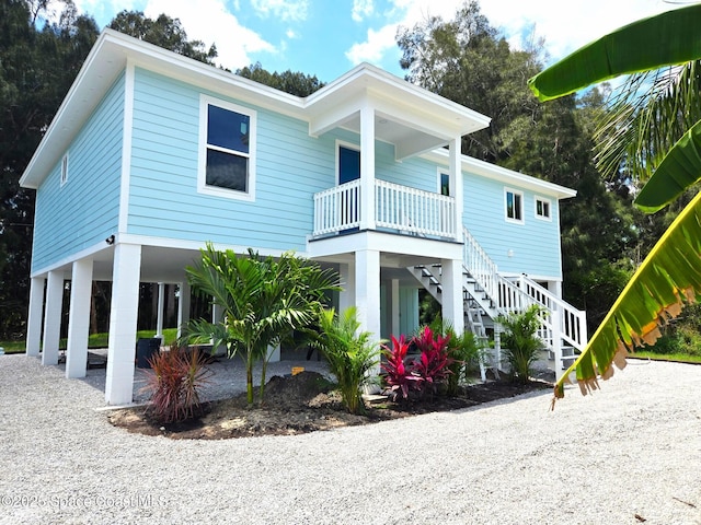 9470 Hibiscus Ave, Sebastian, FL 32976 - coastal home featuring a carport, stairs, dirt driveway, and a porch