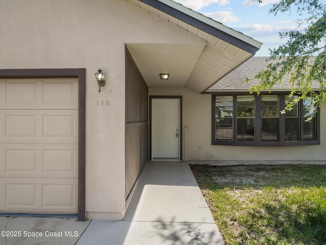 175 Awin Cir SE, Palm Bay, FL 32909 - doorway to property with stucco siding and a garage