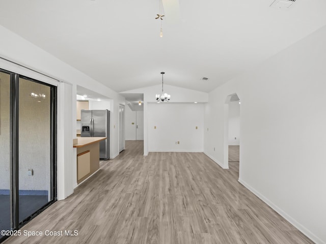 175 Awin Cir SE, Palm Bay, FL 32909 - unfurnished living room featuring lofted ceiling, light wood-style flooring, a chandelier, arched walkways, and baseboards