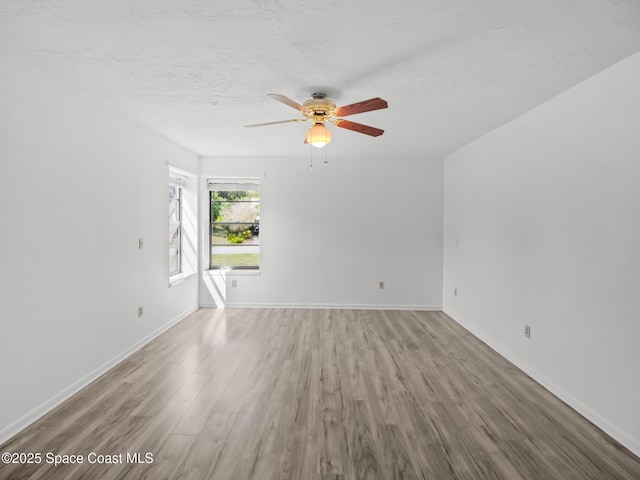 175 Awin Cir SE, Palm Bay, FL 32909 - unfurnished living room with wood finished floors, a ceiling fan, baseboards, and a textured ceiling