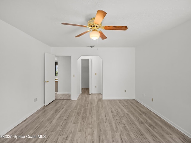175 Awin Cir SE, Palm Bay, FL 32909 - empty room with arched walkways, ceiling fan, light wood finished floors, and baseboards