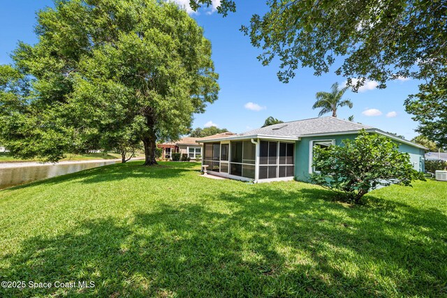 2719 Alicia Ln, Melbourne, FL 32935 - view of grassy yard with a sunroom and central air condition unit