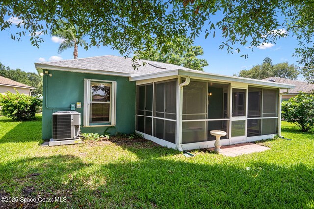 2719 Alicia Ln, Melbourne, FL 32935 - rear view of house with central AC, a lawn, a sunroom, and a shingled roof