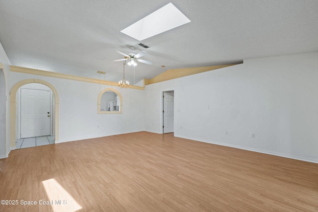2719 Alicia Ln, Melbourne, FL 32935 - unfurnished room with light wood-style flooring, a skylight, a ceiling fan, vaulted ceiling, and baseboards