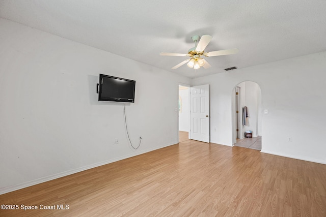 2719 Alicia Ln, Melbourne, FL 32935 - unfurnished living room featuring arched walkways, ceiling fan, light wood finished floors, and baseboards