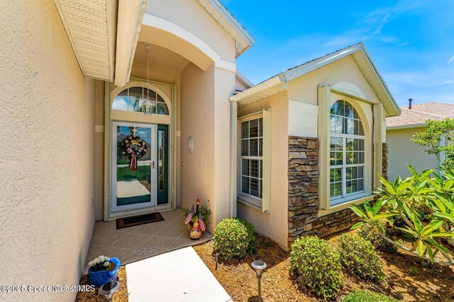 1545 Boca Rio Dr, Melbourne, FL 32940 - doorway to property with stone siding and stucco siding