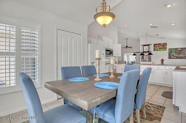 1545 Boca Rio Dr, Melbourne, FL 32940 - dining area featuring light tile patterned flooring and vaulted ceiling
