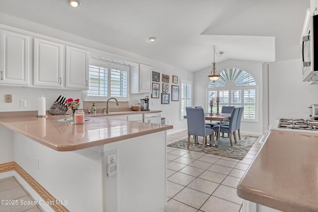 1545 Boca Rio Dr, Melbourne, FL 32940 - kitchen with white cabinets, healthy amount of natural light, a peninsula, vaulted ceiling, and recessed lighting