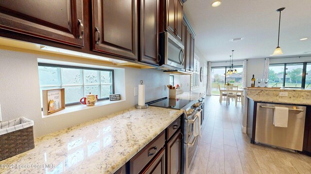 8051 Strom Park Dr, Melbourne, FL 32940 - kitchen with appliances with stainless steel finishes, dark brown cabinets, light stone countertops, pendant lighting, and recessed lighting