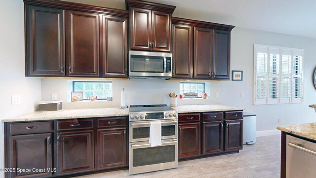 8051 Strom Park Dr, Melbourne, FL 32940 - kitchen with appliances with stainless steel finishes, dark brown cabinets, light stone countertops, and baseboards