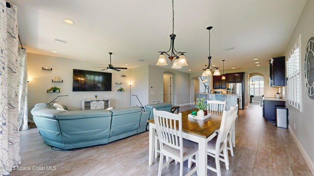 8051 Strom Park Dr, Melbourne, FL 32940 - dining area with arched walkways, light wood-style floors, a ceiling fan, baseboards, and recessed lighting
