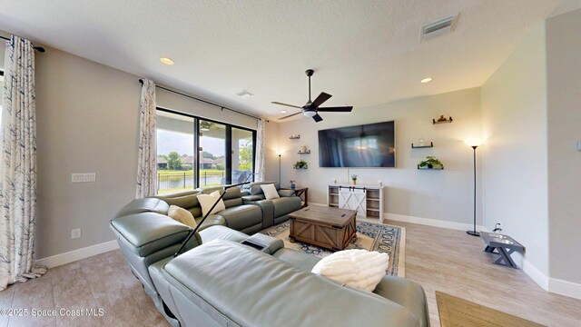 8051 Strom Park Dr, Melbourne, FL 32940 - living room featuring a ceiling fan, recessed lighting, light wood-style flooring, baseboards, and a textured ceiling