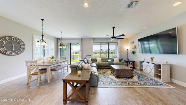 8051 Strom Park Dr, Melbourne, FL 32940 - living room with baseboards, a ceiling fan, light wood-style flooring, recessed lighting, and a textured ceiling