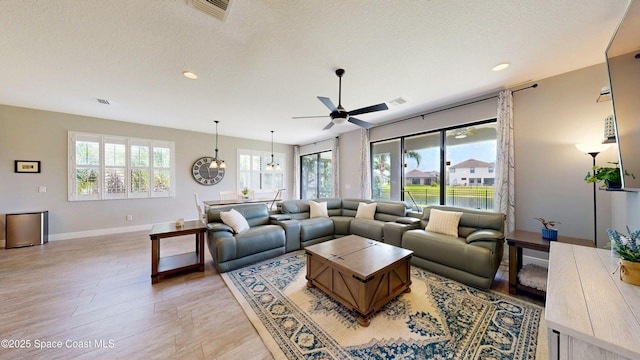8051 Strom Park Dr, Melbourne, FL 32940 - living room featuring baseboards, ceiling fan, light wood-style flooring, recessed lighting, and a textured ceiling