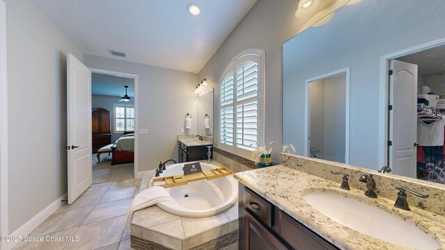 8051 Strom Park Dr, Melbourne, FL 32940 - bathroom with connected bathroom, two vanities, a garden tub, baseboards, and ceiling fan