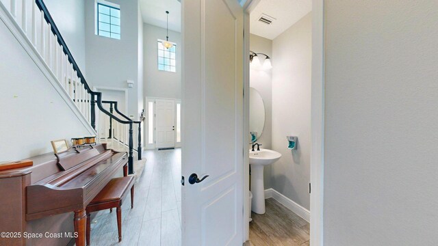8051 Strom Park Dr, Melbourne, FL 32940 - foyer featuring stairs, baseboards, a high ceiling, and light wood-type flooring