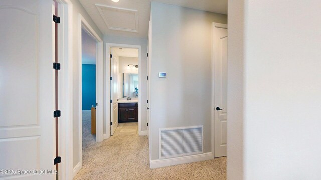 8051 Strom Park Dr, Melbourne, FL 32940 - corridor featuring light colored carpet, attic access, and baseboards
