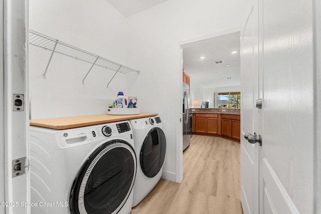 5928 Van Ness Dr, Melbourne, FL 32940 - laundry room with washing machine and clothes dryer, light wood-type flooring, and recessed lighting