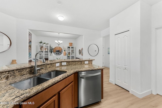 5928 Van Ness Dr, Melbourne, FL 32940 - kitchen with dishwasher, a sink, brown cabinets, light wood-style flooring, and stone counters