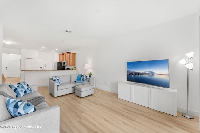 5928 Van Ness Dr, Melbourne, FL 32940 - living room with light wood-style floors, baseboards, and recessed lighting