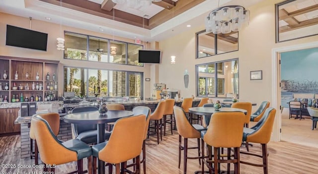 5928 Van Ness Dr, Melbourne, FL 32940 - dining room with ceiling fan, a towering ceiling, healthy amount of natural light, a tray ceiling, and wood finished floors