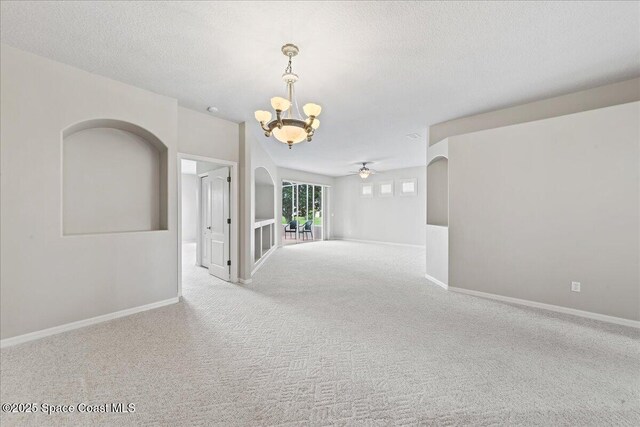 4160 Aberdeen Cir, Rockledge, FL 32955 - spare room featuring a chandelier, carpet flooring, ceiling fan, a textured ceiling, and arched walkways