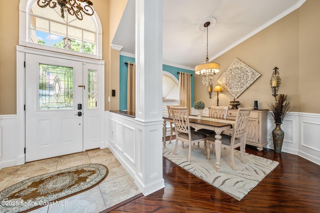3360 Fort Sumter St, Melbourne, FL 32934 - foyer entrance featuring a chandelier, a decorative wall, crown molding, wainscoting, and wood finished floors