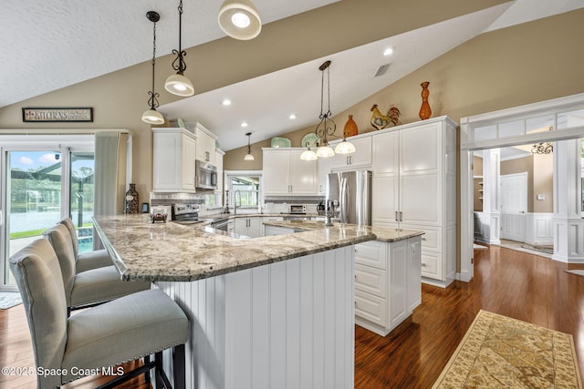 3360 Fort Sumter St, Melbourne, FL 32934 - kitchen with stainless steel appliances, high vaulted ceiling, a peninsula, white cabinetry, and light stone counters