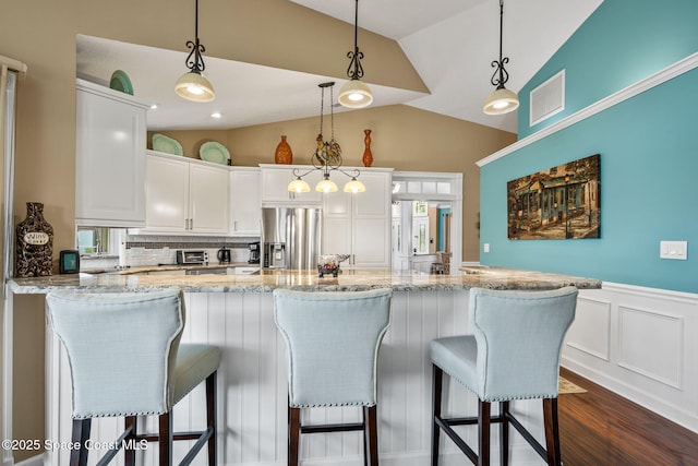 3360 Fort Sumter St, Melbourne, FL 32934 - kitchen with stainless steel fridge with ice dispenser, lofted ceiling, dark wood-style flooring, white cabinets, and tasteful backsplash